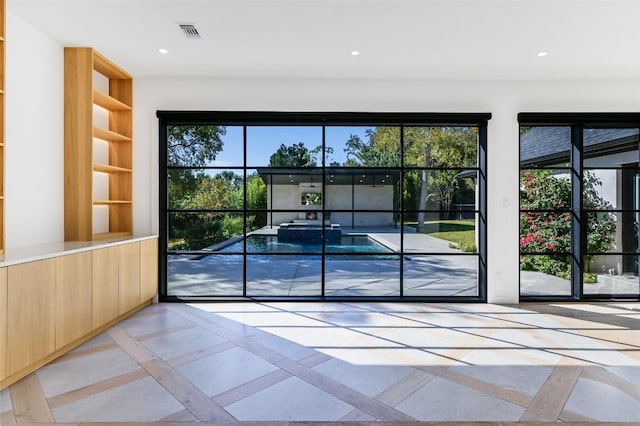 doorway to outside featuring recessed lighting, visible vents, and a wealth of natural light