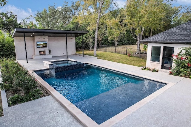 view of swimming pool with a pool with connected hot tub, fence, a lawn, a warm lit fireplace, and a patio