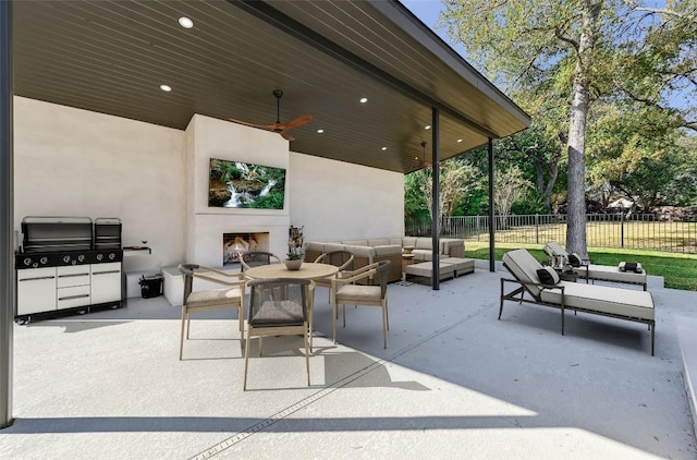 view of patio with an outdoor living space with a fireplace, ceiling fan, and fence