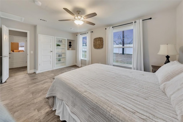 bedroom featuring visible vents, baseboards, light wood-style flooring, and a ceiling fan