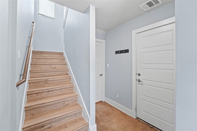 stairway with baseboards and visible vents