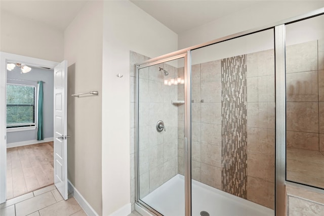 bathroom with tile patterned floors, baseboards, and a stall shower