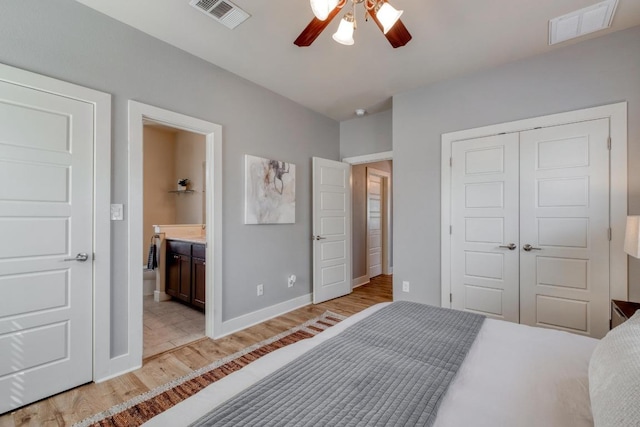 bedroom with light wood-style floors, visible vents, a closet, and baseboards