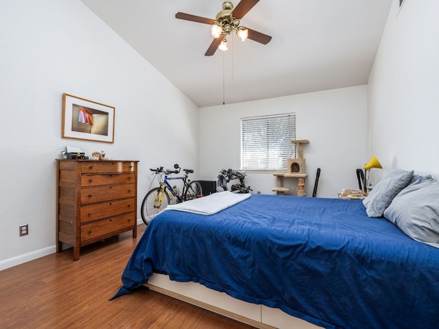 bedroom featuring ceiling fan, baseboards, lofted ceiling, and wood finished floors