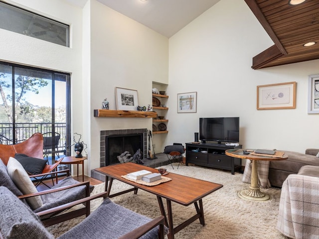 living room featuring built in features, a tile fireplace, and a towering ceiling