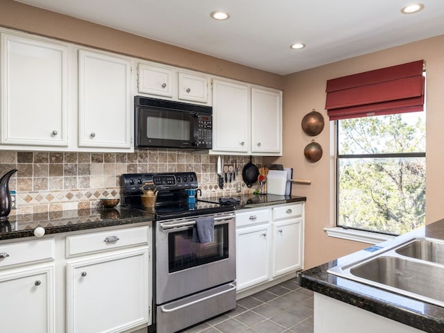 kitchen featuring backsplash, black microwave, stainless steel electric stove, tile patterned floors, and white cabinetry