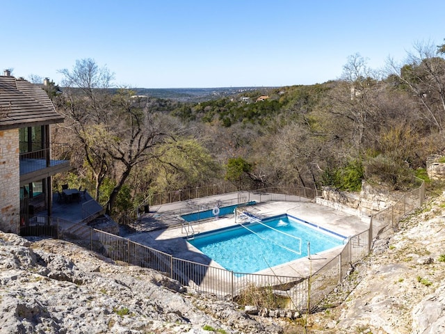 view of swimming pool featuring a patio, fence, and a fenced in pool