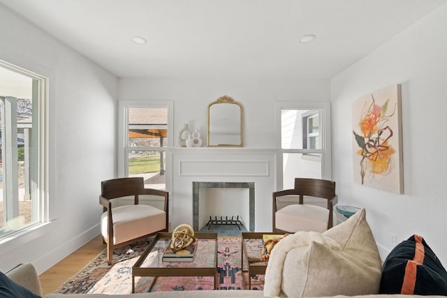 living area with recessed lighting, baseboards, wood finished floors, and a fireplace