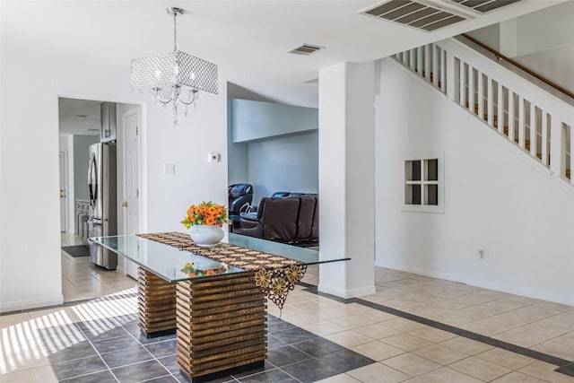 kitchen featuring visible vents, a chandelier, tile patterned flooring, and freestanding refrigerator