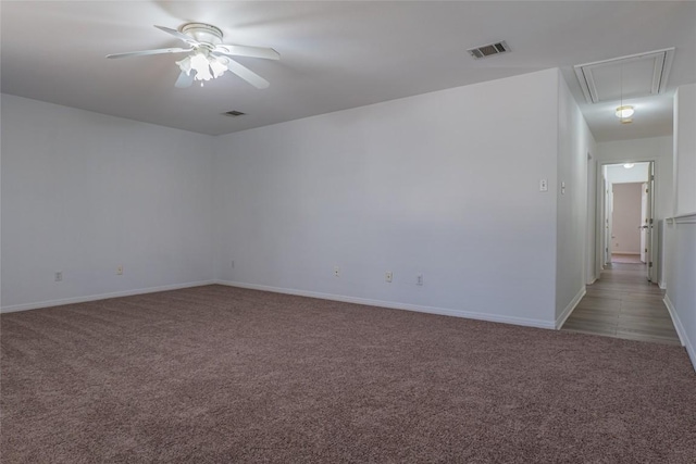 unfurnished room with visible vents, light carpet, attic access, and ceiling fan