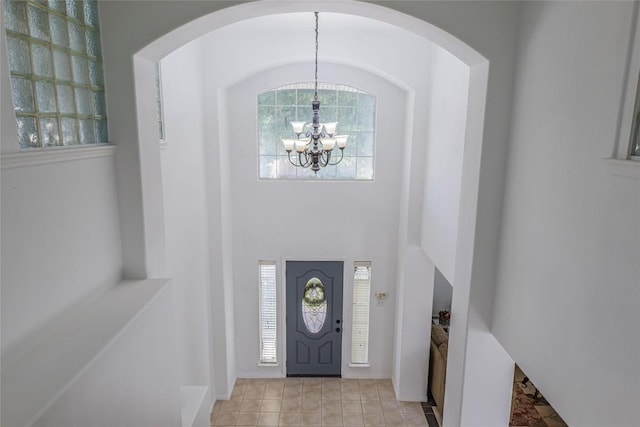 foyer featuring a chandelier, a high ceiling, and a wealth of natural light