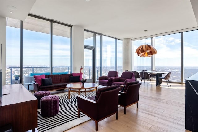 living room featuring a wall of windows and light wood-type flooring