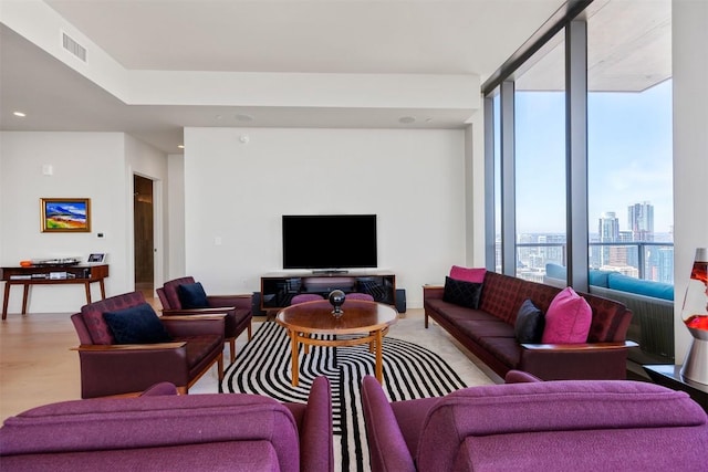 living area featuring floor to ceiling windows, recessed lighting, visible vents, and light wood finished floors