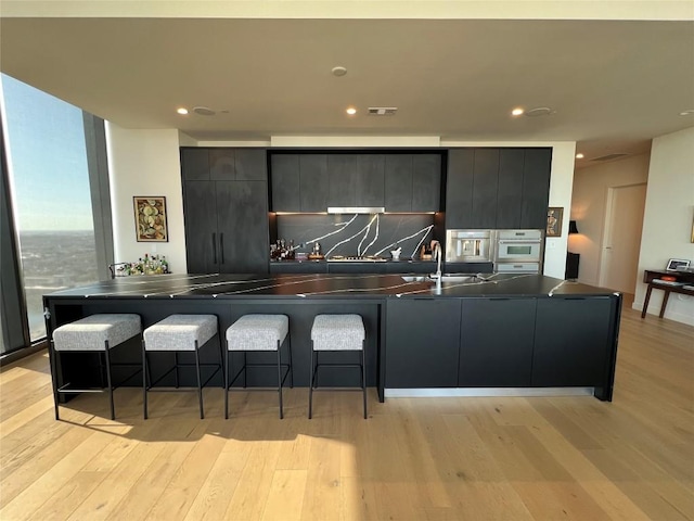 kitchen featuring light wood-type flooring, dark countertops, and modern cabinets