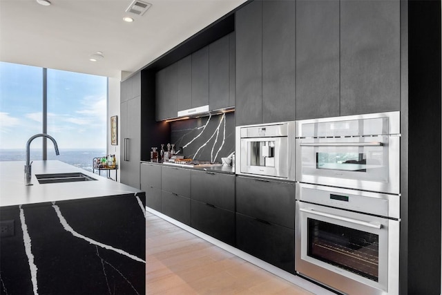 kitchen with modern cabinets, visible vents, stainless steel appliances, and a sink