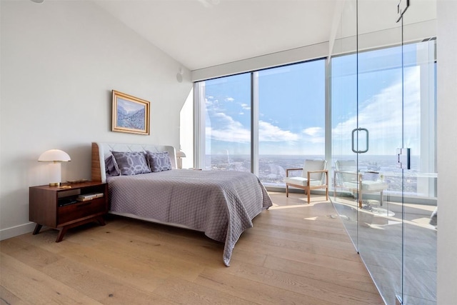 bedroom featuring lofted ceiling and light wood-style floors