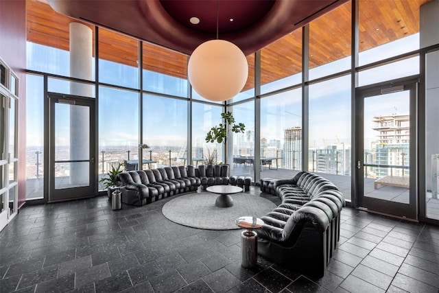 living room with stone tile flooring, a city view, and a wall of windows