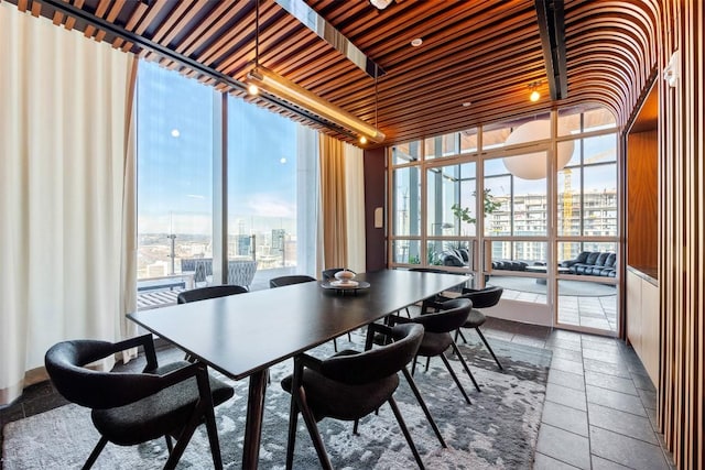 dining area with a city view, a healthy amount of sunlight, and a wall of windows