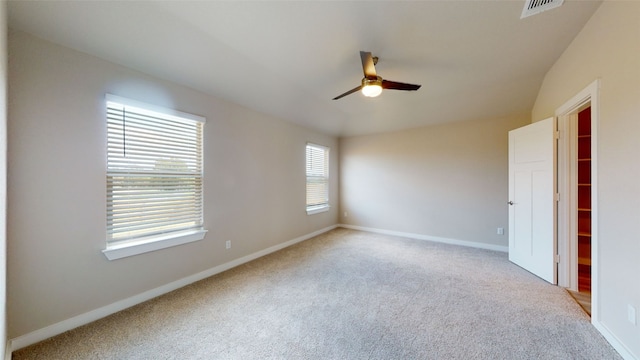 empty room featuring light carpet, visible vents, ceiling fan, and baseboards