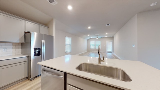 kitchen featuring visible vents, gray cabinets, a sink, stainless steel appliances, and light countertops