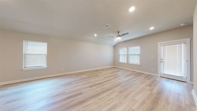 empty room featuring visible vents, recessed lighting, light wood-style floors, baseboards, and vaulted ceiling