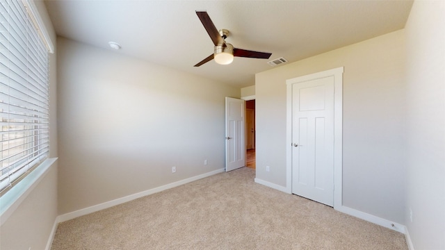 unfurnished bedroom with baseboards, visible vents, and light carpet