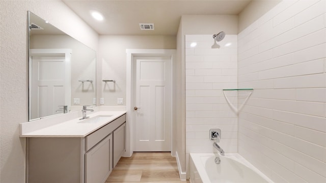 bathroom featuring visible vents, shower / tub combination, wood finished floors, and vanity