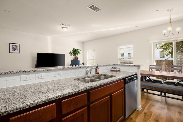 kitchen featuring light wood finished floors, visible vents, dishwasher, and a sink