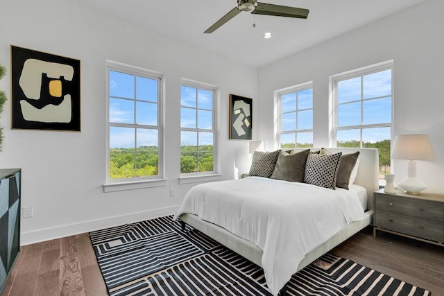 bedroom with recessed lighting, multiple windows, baseboards, and wood finished floors