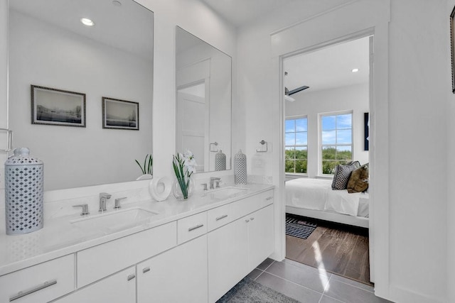 full bath featuring tile patterned flooring, double vanity, ensuite bath, and a sink