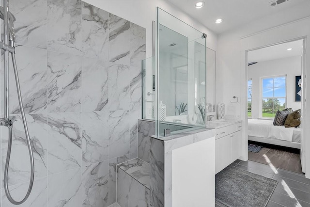 bathroom featuring a marble finish shower, visible vents, recessed lighting, and ensuite bath