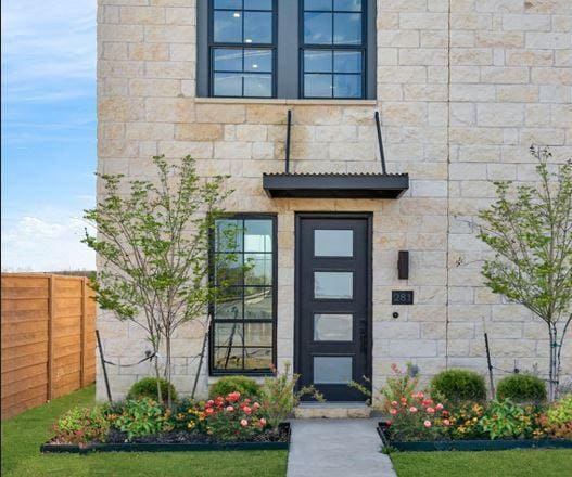 property entrance featuring fence and stone siding