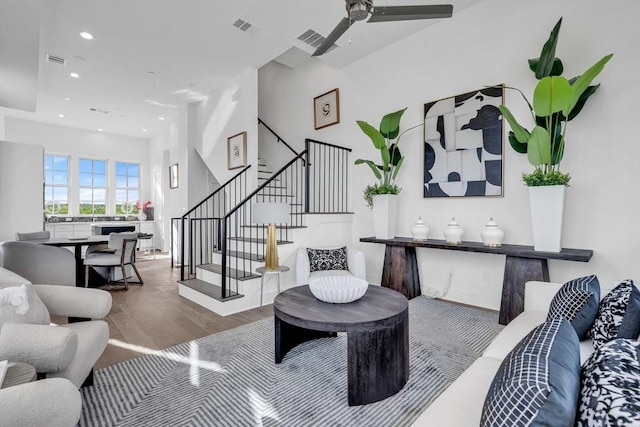 living room featuring stairs, recessed lighting, wood finished floors, and visible vents