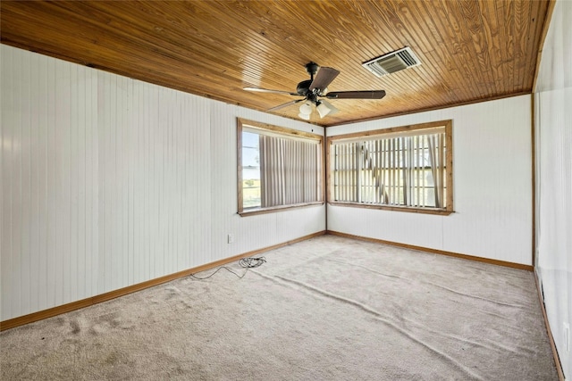 empty room with wood ceiling, carpet flooring, a ceiling fan, and visible vents
