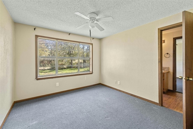 spare room featuring baseboards, carpet floors, and a textured ceiling