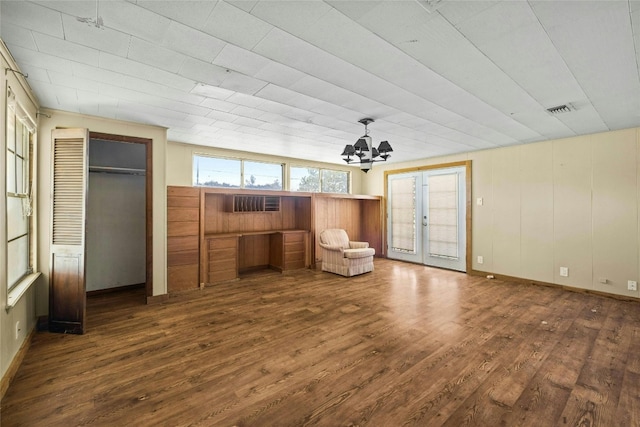 unfurnished room with visible vents, dark wood-type flooring, an inviting chandelier, and french doors