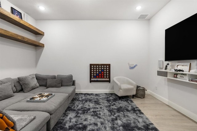 living room with recessed lighting, visible vents, baseboards, and light wood finished floors