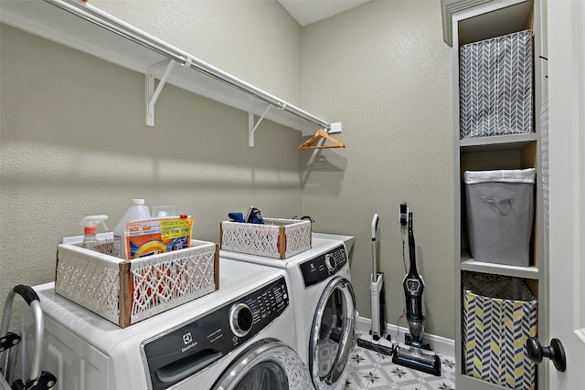 clothes washing area with laundry area, baseboards, independent washer and dryer, and light floors