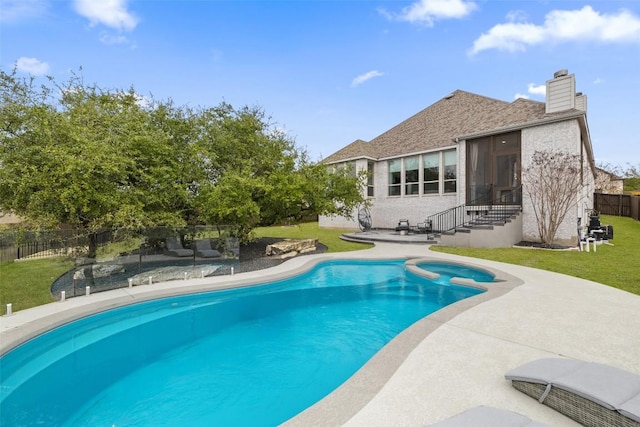 view of swimming pool with a pool with connected hot tub, fence, entry steps, a yard, and a patio area