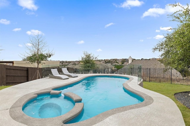 view of swimming pool featuring a patio, a fenced backyard, and a pool with connected hot tub