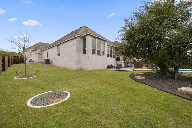 exterior space featuring a patio area, a yard, a fenced backyard, and central AC