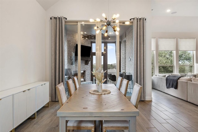 dining room with vaulted ceiling, radiator heating unit, light wood-type flooring, and a chandelier