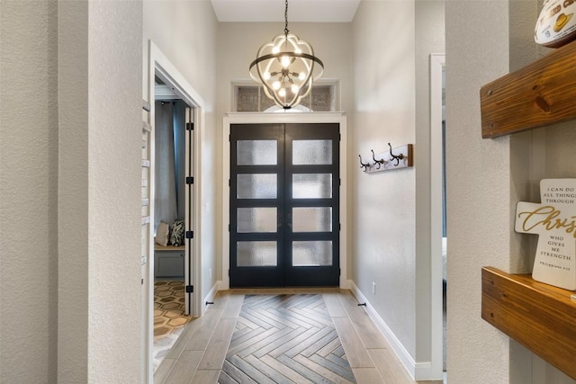 entryway featuring baseboards and an inviting chandelier