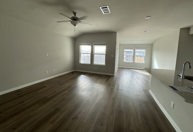 unfurnished living room featuring visible vents, ceiling fan, baseboards, dark wood finished floors, and lofted ceiling