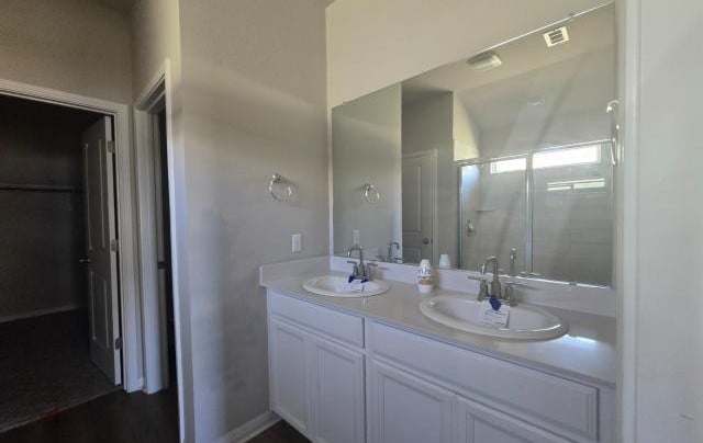 full bathroom with a sink, visible vents, and double vanity