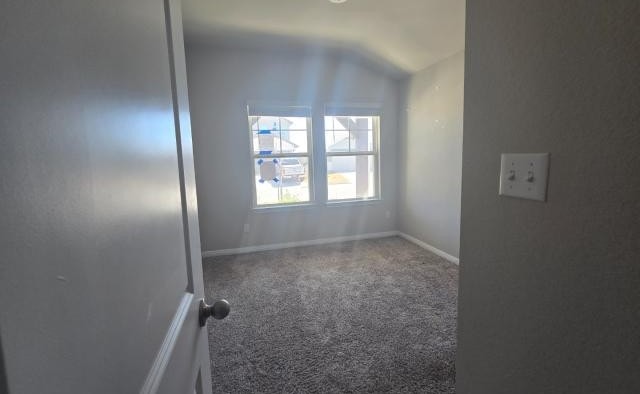 carpeted spare room featuring baseboards