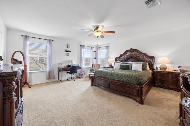 bedroom featuring visible vents, light carpet, baseboards, and ceiling fan