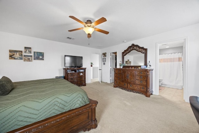 bedroom with ensuite bath, carpet, visible vents, and ceiling fan