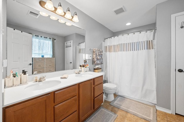 bathroom with double vanity, visible vents, and a sink