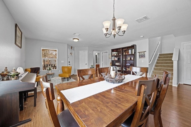 dining room featuring stairway, wood finished floors, and visible vents